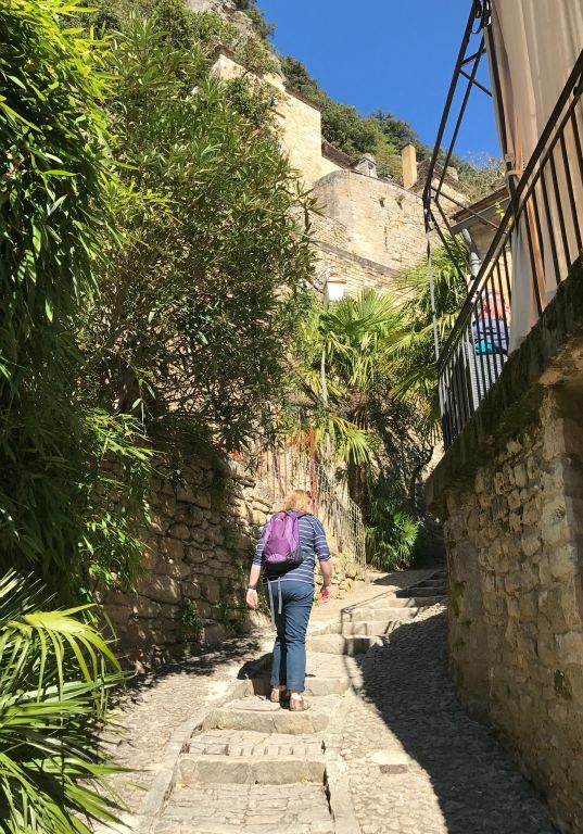Judith climbing some stairs into the village of La Roque-Gageac.