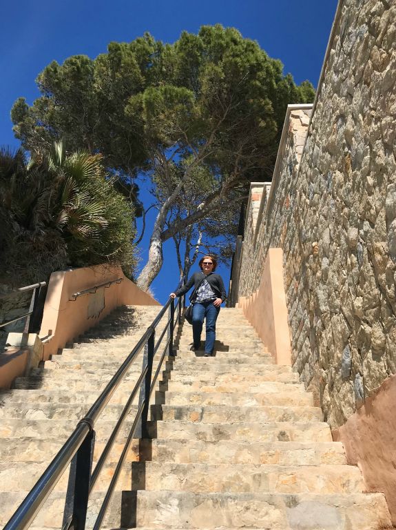 Judith walking down the stairs to the seafront at Camp de Mar.